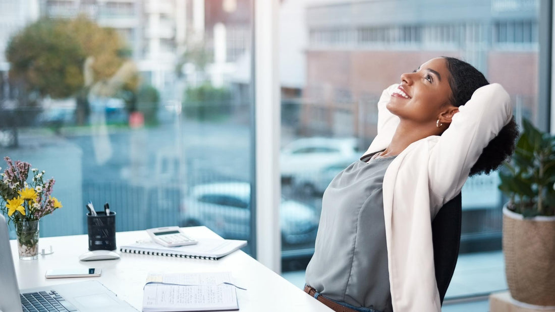 Mujer sentada en su escritorio, mirando hacia arriba.