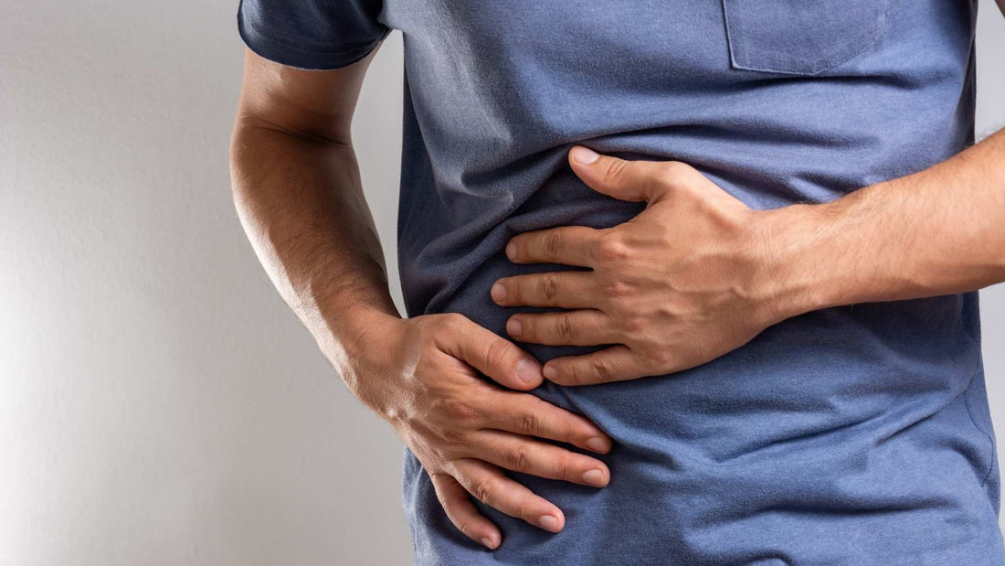 Hombre con las manos en el estómago, reflexionando sobre la necesidad de un "reset" digestivo en su cuerpo.