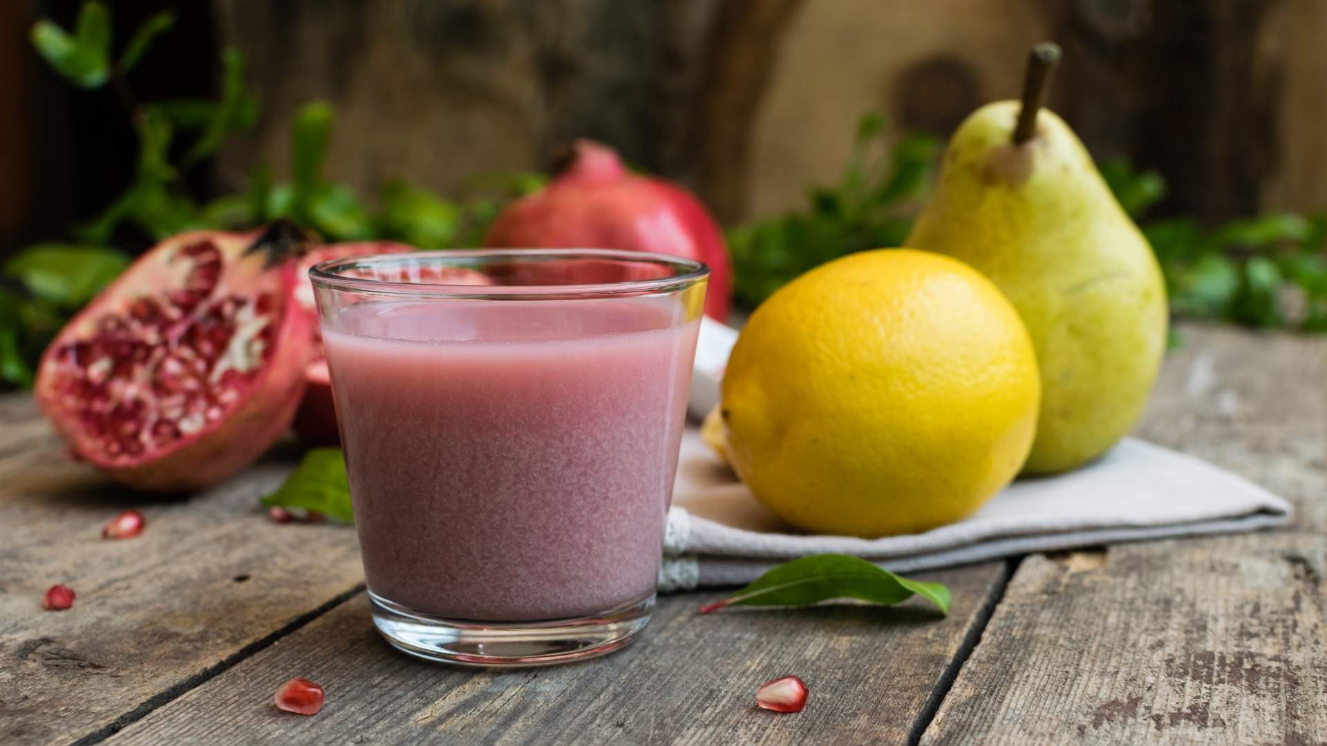 Un vaso de jugo con granada y limones, parte de la fórmula Glow para una bebida refrescante y saludable.