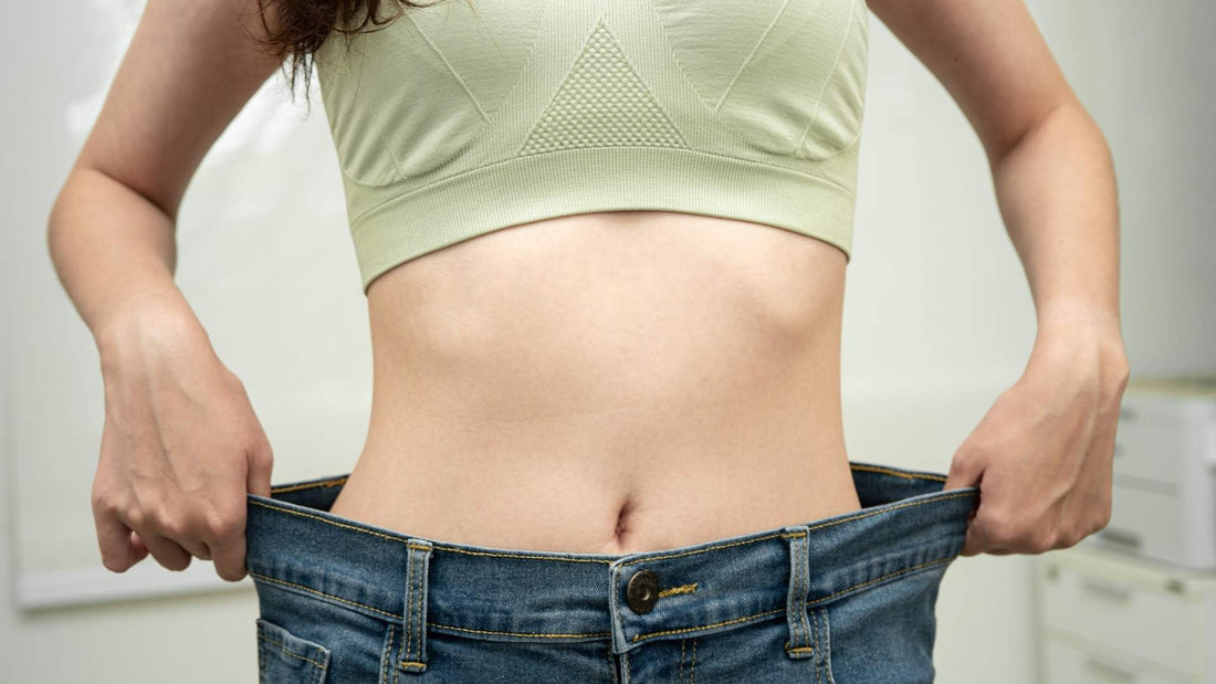 Mujer mostrando sus jeans mientras se sostiene la cintura