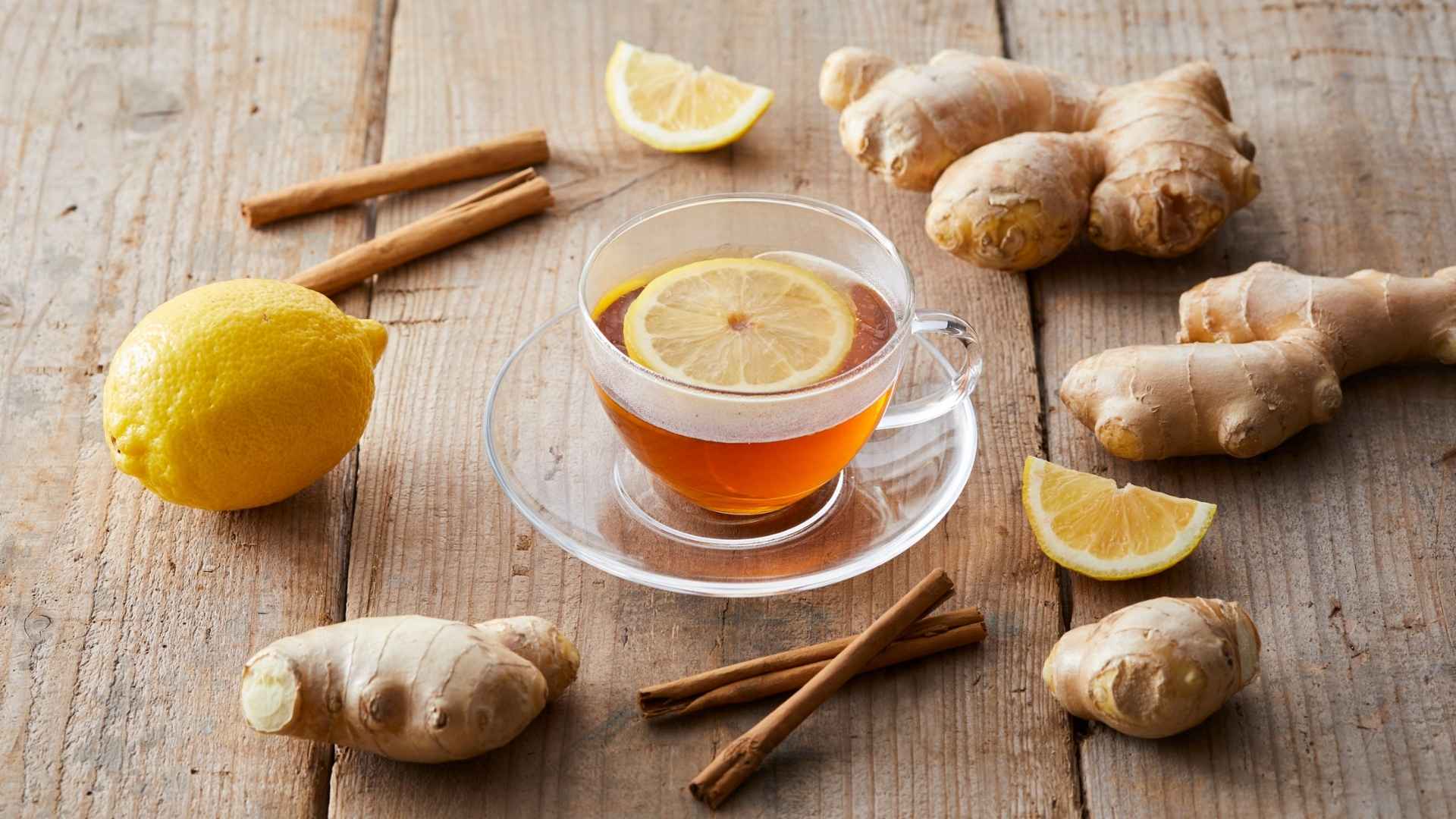 Té de jengibre con limón y canela sobre una mesa de madera.