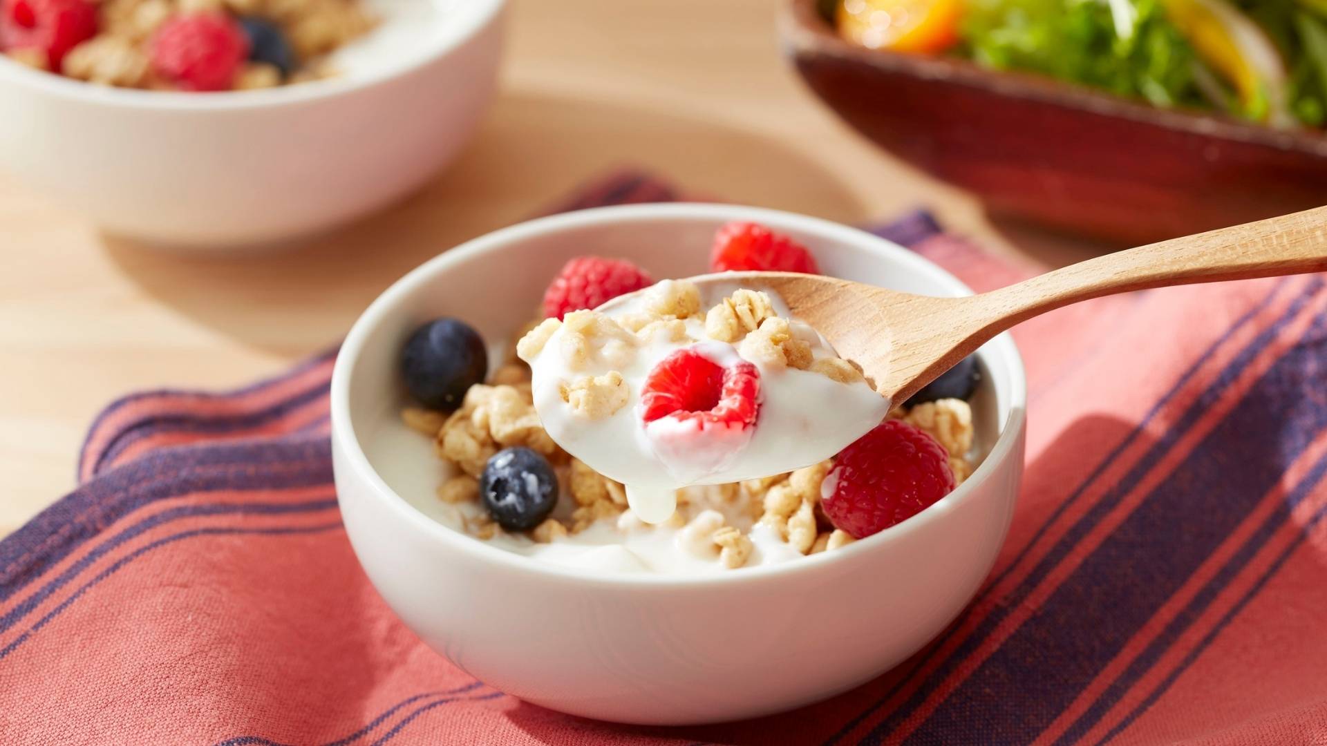 Yogur cremoso con frutas y bayas, rico en probióticos, prebióticos y posbióticos para una alimentación saludable.
